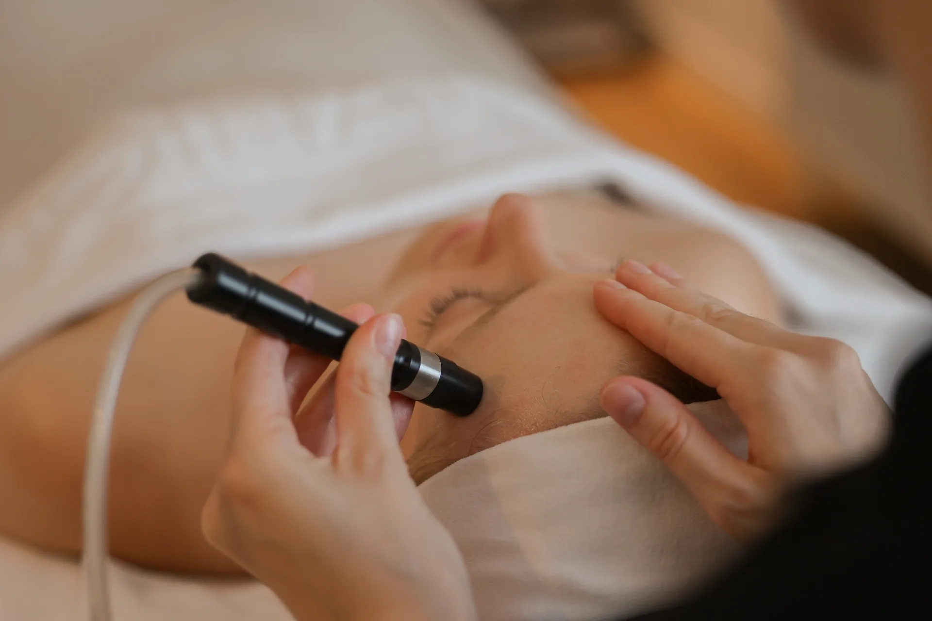 Specialist voert een BellaPeel-behandeling uit met een professioneel exfoliatie-apparaat